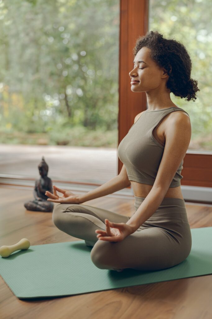 woman-in-headphones-practicing-yoga-and-listen-meditation-at-home-sitting-in-lotus-pose-on-mat-682x1024 Cómo Hidratar los Discos Intervertebrales: Una Guía Esencial para la Salud de tu Columna Vertebral